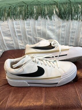 Nike White Sneakers with Black Swoosh and Gold Accent